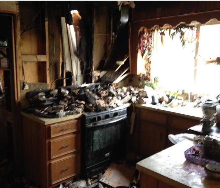 burned kitchen, debris on stove, counters, broken walls