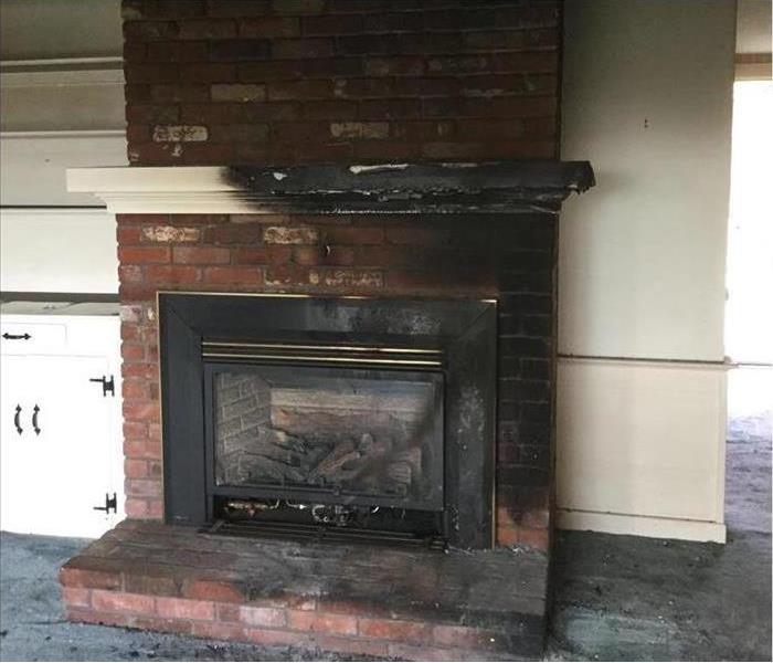 scorched fireplace mantle and bricks, dirty carpet